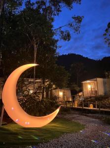 a light up crescent moon sculpture in a yard at night at Kireina Genting Villa in Genting Highlands
