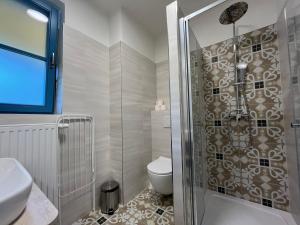 ein Bad mit einer Dusche, einem WC und einem Waschbecken in der Unterkunft Hotel Edvard in Frenštát pod Radhoštěm
