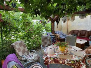 una mesa y sillas en un jardín con mesa en Penzión u Aďky en Podhájska