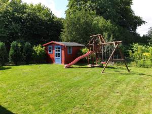 einen Spielplatz mit Rutsche im Hof in der Unterkunft Ferienhaus Familienidyll Usedom mit Garten & WLAN in Zinnowitz