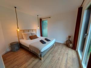 um quarto com uma cama e uma grande janela em PURE, maison au calme à 10 min du centre ville em Quimper