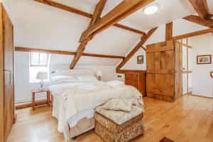 a bedroom with a large bed and wooden ceilings at Thatch Close Cottages in Ross on Wye
