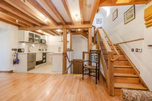 a kitchen and staircase in a home with wooden ceilings at Thatch Close Cottages in Ross on Wye +48 photos