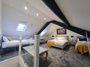 a attic bedroom with two beds and a couch at Beautiful 4 bedroom house near town centre. With Bike Store Perfect for Bike Park Wales in Merthyr Tydfil