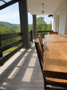 a wooden table and chairs on a deck with a view at Flow House in Satu Mare