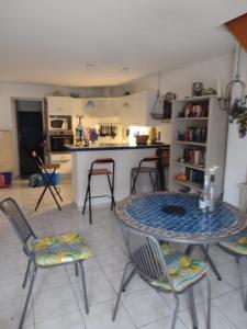 a kitchen with a table and chairs in a room at Mas de la garrigue 13 in Saint Pierre La Mer