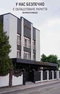 a building with a sign on the front of it at Rudison Hotel & Restaurant in Ternopilʼ