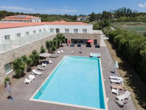 an overhead view of a swimming pool with chairs and a building at Hotel Vila D'Óbidos in Óbidos