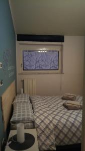 een slaapkamer met 2 bedden en een raam bij LOFT Il "Nido degli Angeli" in Cuneo