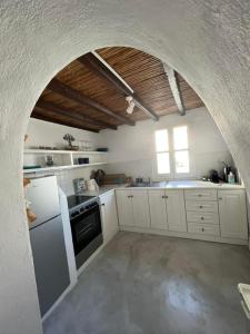 a kitchen with white cabinets and an arched doorway at The Pulse Residence Astypalea in Astypalaia