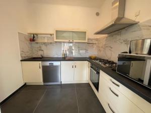 a kitchen with white cabinets and black counter tops at Floramarine in Saint-Raphaël