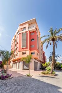 un bâtiment avec des palmiers en face de celui-ci dans l'établissement ZARI BOUTIQUE ApartHotel, à Marrakech