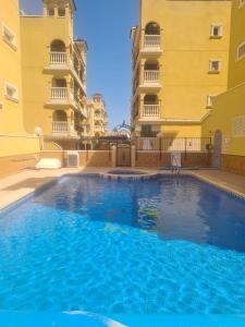 a swimming pool in the middle of two buildings at Casa suerte in Algorfa