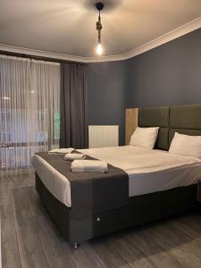 1 dormitorio con 1 cama grande con sábanas blancas en Centrum Residence, en Ankara