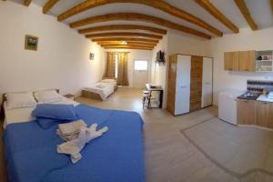 Großes Zimmer mit einem blauen Bett und einer Küche. in der Unterkunft La Toscana Costinești in Schitul + 75 Fotos