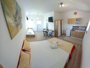 ein Schlafzimmer mit einem großen weißen Bett und einer Küche in der Unterkunft La Toscana Costinești in Schitul