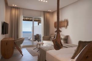 a bedroom with a swinging bed with a view of the ocean at Armony Suites Milos in Paliochori
