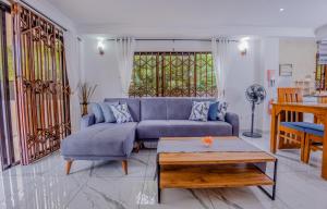 a living room with a blue couch and a table at The Cove Holiday Apartment in Bel Ombre