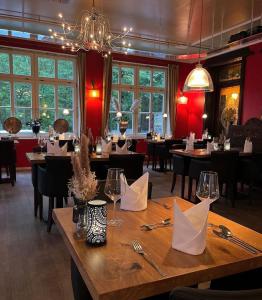 een restaurant met tafels en stoelen en een kroonluchter bij Hotel Bentheimer Hof in Bad Bentheim