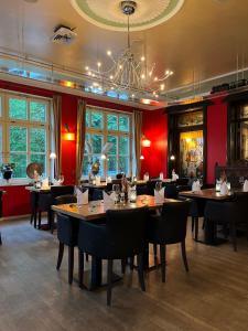 een restaurant met tafels en stoelen en een kroonluchter bij Hotel Bentheimer Hof in Bad Bentheim
