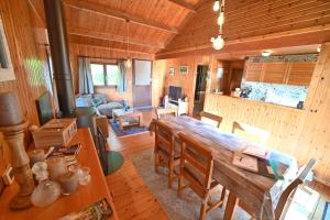 a dining room with a large wooden table in a cabin at Hortensias in Somme-Leuze