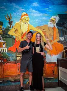 a man and a woman standing in front of a mural at The White Canyon Hotel in Varanasi