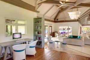 a large living room with a desk and chairs at Tamassa Bel Ombre in Bel Ombre
