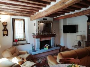 sala de estar con 2 sofás y chimenea en Ai tre Campi, en Fornaci di Barga