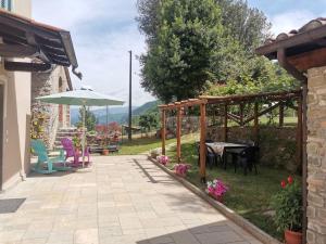 a patio with a table and chairs and an umbrella at Ai tre Campi in Fornaci di Barga