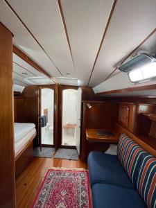 a small room with a blue couch and a rug at Beautiful and comfortable sailboat with secure parking available in Barcelona