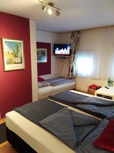 Hotel/Restaurant Adria في فيندهاغن: غرفة نوم بسريرين وتلفزيون على الحائط