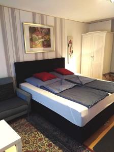 ヴィントハーゲンにあるHotel Garni "Adria"の大きなベッドと椅子のある寝室