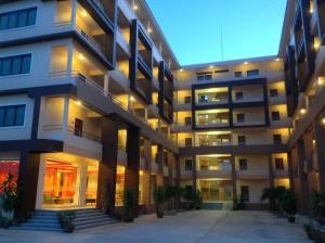 un gran edificio de apartamentos con luces encendidas en Perfect Place Hotel, en Suratthani