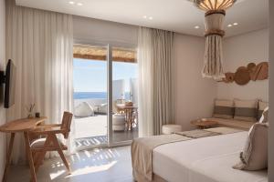 a bedroom with a bed and a view of the ocean at Armony Suites Milos in Paliochori