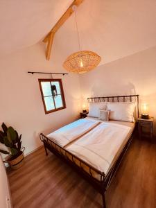 a bedroom with a large bed with a chandelier at Echternacher Hof - Moselloft in Kinheim