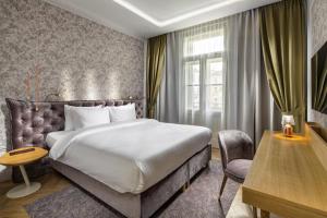 a hotel room with a bed and a desk and a chair at Mamaison Hotel Riverside Prague in Prague