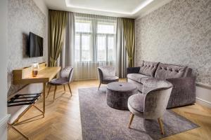 a living room with a couch and a table and chairs at Mamaison Hotel Riverside Prague in Prague
