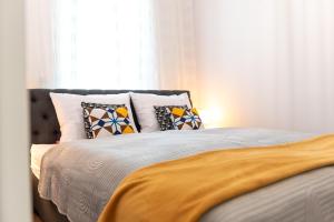 a bedroom with a bed with pillows and a window at Apartament LUX 3 Cieplice in Jelenia Góra