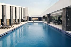 een groot zwembad met blauw water in een gebouw bij Crowne Plaza Hotel Riyadh Minhal, an IHG Hotel in Riyad