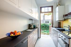 a kitchen with a bowl of fruit on the counter at Le Monarque - Appartement avec jardin in Chaville