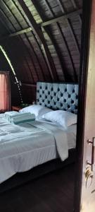 a bedroom with a large bed with white sheets at D'kailash Retreat in Singaraja