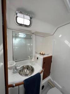 a small bathroom with a sink and a mirror at Beautiful and comfortable sailboat with secure parking available in Barcelona