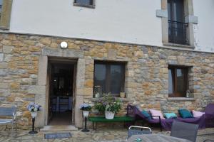 - un bâtiment en pierre avec une table et des chaises devant dans l'établissement el calero, à Oviedo