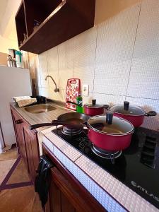 two pots and pans on a stove in a kitchen at Residencial Bem-te-vi in Jericoacoara
