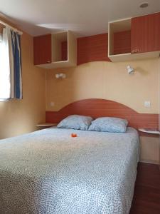 a bedroom with a large bed with a wooden headboard at Casitas Mobil Home in Villa de Mazo