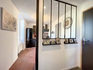 a hallway with a door with pictures and a refrigerator at Appart LA MANUFACTURE - Maison 1911 - confort & prestige in Gien