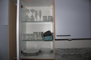 einen Kühlschrank mit Tellern und Gläsern auf Regalen in der Unterkunft Studio-Appartement Neunburg vorm Wald in Neunburg vorm Wald