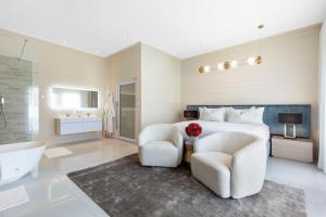 1 dormitorio con 1 cama, 2 sillas y bañera en Fauchil Boutique Hotel en Johannesburgo
