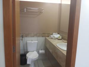 a bathroom with a toilet and a sink at Flat Le Jardin Suites in Caldas Novas