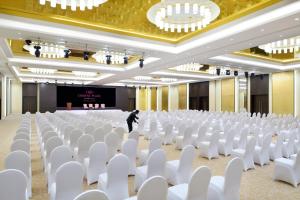 a room with white chairs and a man standing in front of a stage at Crowne Plaza Hotel Riyadh Minhal, an IHG Hotel in Riyadh